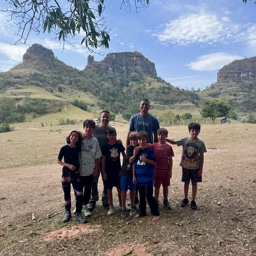 Grupo de família e guia reunido depois da trilha, com a cuesta ao fundo