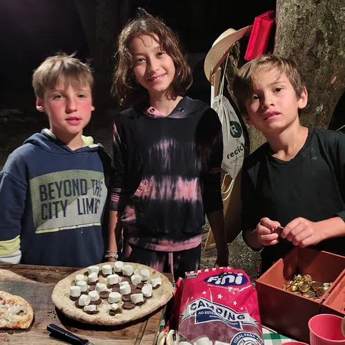 Crianças no lanche da noite, com pizza e marshmallow